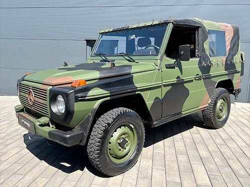 Mercedes G Wolf Bundeswehr Geländewagen Oldtimer in Tarnfarben auf Holzplattform vor grauer Halle